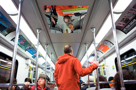 男性向け薄毛対策会社(Panorama Hair)の車内広告。頭髪上部を写すよう配置されたミラーで、薄毛の問題解決を促進するようです。<カナダ>