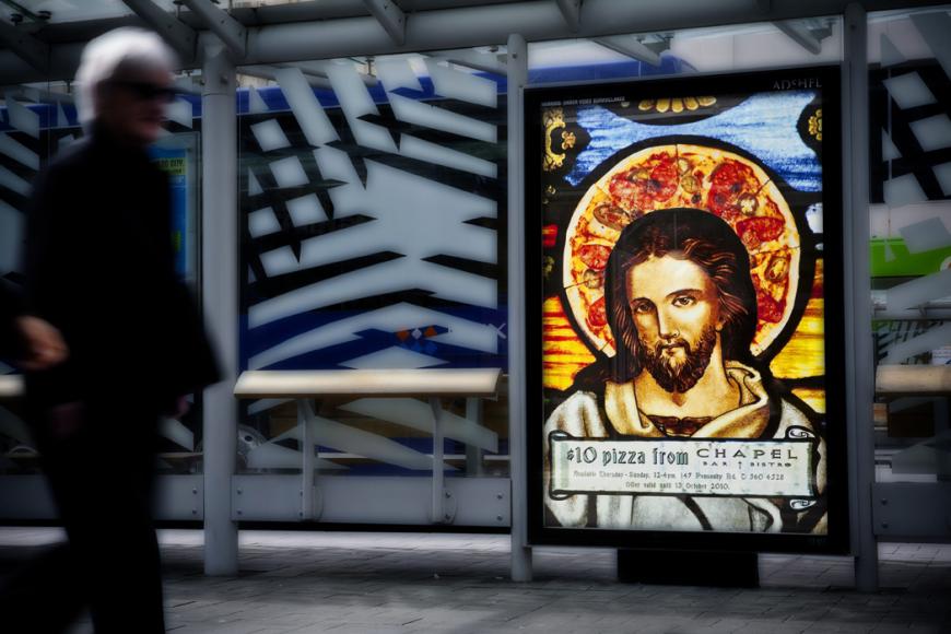 レストランのバスシェルター広告。イエスキリストのような男性の背後を射すのは、ピザでできた後光。アイデアの評価はさておき、賛否両論があったようですw<ニュージーランド>